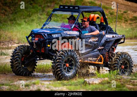 Ein ATV mit Leuten, die beim Rock Fest 2020 auf einem schmutzigen Schlammfeld herumfahren und Rennen Stockfoto