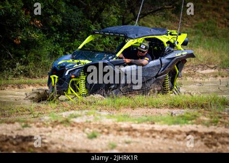 Ein ATV mit Leuten, die beim Rock Fest 2020 auf einem schmutzigen Schlammfeld herumfahren und Rennen Stockfoto