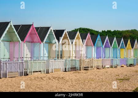 Mersea Essex UK, Blick im Sommer auf bunte Strandhütten am Sandstrand in West Mersea, Mersea Island, Essex, England, Großbritannien Stockfoto