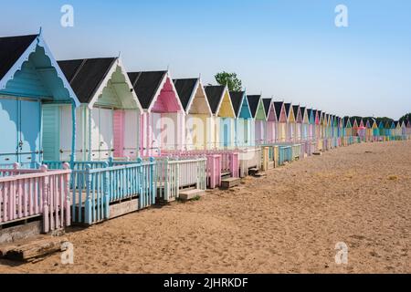 Essex UK Beach, Blick im Sommer auf bunte Strandhütten am Sandstrand in West Mersea, Mersea Island, Essex, England, Großbritannien Stockfoto