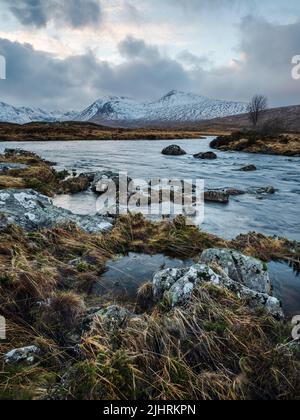 Blick über Loch Ba in Richtung verschneite Berge, Rannoch Moor, Schottland Stockfoto