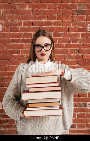 Schöner Lehrer, der eine Liste von Büchern zum Lesen gibt Stockfoto