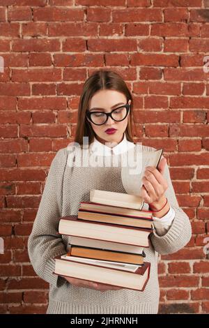 Schönes Mädchen, das Lehrbuch liest, freier Platz Stockfoto