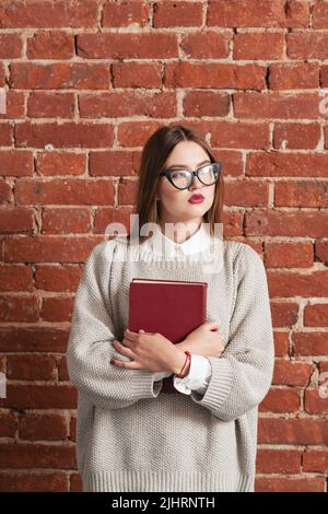 Student Mädchen stehen mit Lehrbuch, freien Raum Stockfoto