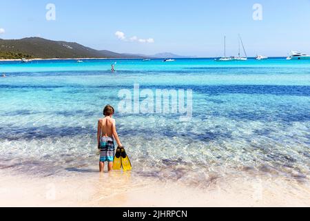 Junge, der an einem schönen Strand Sakarun mit Flossen in der Hand steht, Dugi otok, Kornati Stockfoto