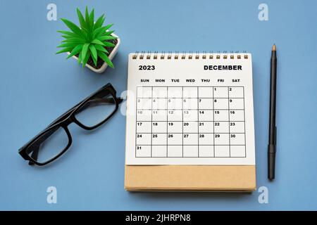 Dezember 2023 Tischkalender auf blauem Hintergrund. Direkt darüber. Flach liegend. Stockfoto