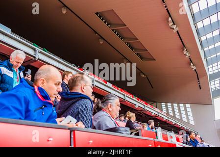 Menschen auf den Tribünen. Rote Stühle in den Anfield-Ständen. Anfield ist ein Fußballstadion in Anfield, Liverpool, Merseyside, England, das über einen Sitzbereich verfügt Stockfoto