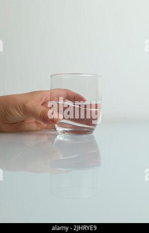 Handfangende Glas Wasser spritzt auf weißem Hintergrund Stockfoto