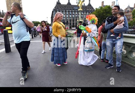 London, England, Großbritannien. Ein farbenfroher Ballonverkäufer spricht mit einem Anbieter von Rosen auf der Westminster Bridge, Juli 2022 Stockfoto