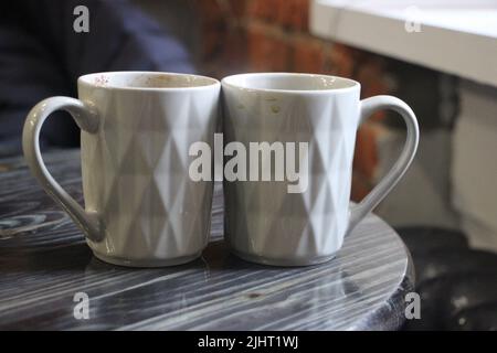 Zwei Espresso-Kaffees in kleinen weißen Tassen auf dem grauen Holztisch im Café. Liebe und Beziehung Konzept Stockfoto