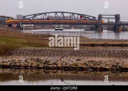 Stahlbau Ziehen Sie Brücke über den Fluss IJssel mit einem niederländischen Eisenbahn-Zug über sie Stadt Zutphen im Rücken und Frachtschiff Wohltäter Stockfoto