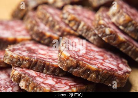 Getrocknete Wurststücke aus der Nähe. Sausage im Vollformat. Köstliche Vorspeise mit Fleisch. Stockfoto