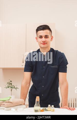 Junger, gutaussehender Mann, der im Freiraum des Spa-Salons arbeitet Stockfoto