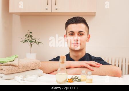 Porträt eines hübschen männlichen Masseurs in schwarzer Schürze Stockfoto