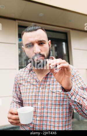 Schickes Hipster mit Kaffee- und Zigarettenporträt Stockfoto