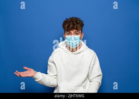Überraschte den jungen kaukasischen, gutaussehenden Mann, der etwas zeigte Stockfoto