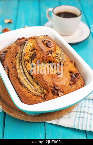 Bananenbrot oder Kuchen mit Schokolade und Walnüssen mit einer Tasse Kaffee. Köstliches hausgemachtes Dessert, leckerer Snack oder Frühstück am Morgen. Stockfoto