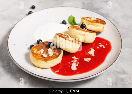 Quark Pfannkuchen, Ricotta Fritters oder Syrniki mit Johannisbeere. Gesundes und leckeres Frühstück am Morgen. Stockfoto