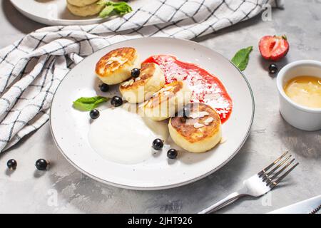 Quark Pfannkuchen, Ricotta Fritters oder Syrniki mit Johannisbeere. Gesundes und leckeres Frühstück am Morgen. Stockfoto
