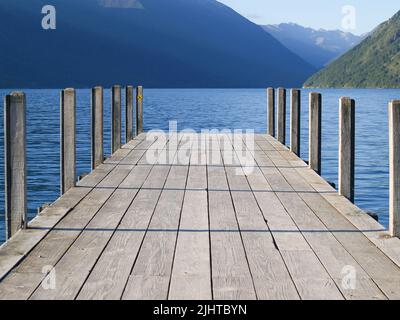 Steg am Roto-iti-See, der in den See mit Berghintergrund projiziert wird, Tasman Lakes District, Neuseeland. Stockfoto