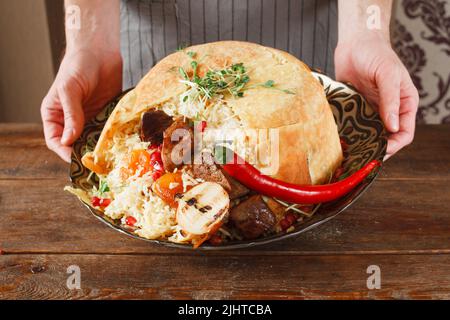 Shah pilaff auf großer Platte, die in den Händen hält Stockfoto