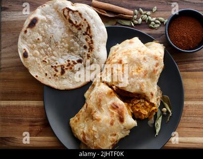 Chicken-Pudro-Roti oder Salomie. Traditionelles Essen, eine Salomie Roti gefüllt mit einem mit einem Salz gefüllten, mit einem Schaber gefüllten Gericht Stockfoto