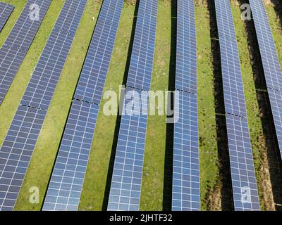Luftaufnahme von Reihen von Solarzellen in einem Feld Bauernhof instaked. Keine Personen. Stockfoto