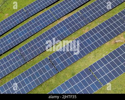 Luftaufnahme von Reihen von Solarzellen in einem Feld Bauernhof instaked. Keine Personen. Stockfoto