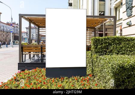 Große Plakatwand in der Nähe des Straßencafés der Stadt. Außenwerbung Plakat für die Förderung von Restaurant oder smth sonst in schönen historischen Ort mit Blumen. Hochwertige Fotos Stockfoto