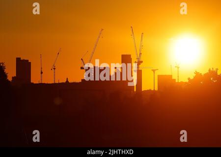 Turmdrehkrane im Zentrum von Leeds, West Yorkshire, Großbritannien, wurden gegen einen Sonnenaufgang silhouettiert Stockfoto