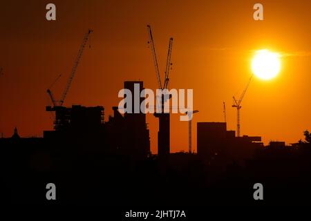 Turmdrehkrane im Zentrum von Leeds, West Yorkshire, Großbritannien, wurden gegen einen Sonnenaufgang silhouettiert Stockfoto