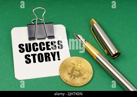 Kryptowährung und Geschäftskonzept. Auf einer grünen Fläche, einer Bitcoin-Münze, einem Stift und einem Blatt Papier mit der Aufschrift - Success Story Stockfoto