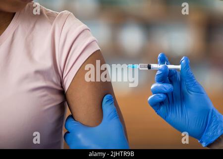 Krankenschwester, die Injektion für schwarze Patientin macht, abgeschnitten Stockfoto