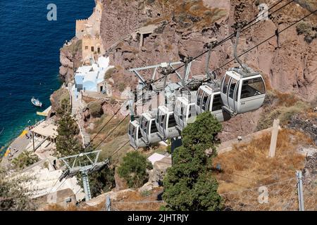 Mann auf einer Seilbahn, die die Linie repariert. Die Seilbahn fährt von Fira Town zum alten Hafen und zurück nach Fira Town. Thira, Santorini, Griechenland Stockfoto