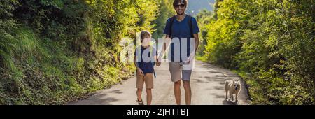 Vater und Sohn gehen mit einem Hund in einem Nationalpark-BANNER, LANGFORMATIG Stockfoto
