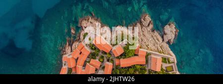 BANNER, LANGFORMAT-AEROPHOTOGRAPHIE. Blick von der fliegenden Drohne. Panoramablick auf die Insel Sveti Stefan in Budva an einem schönen Sommertag, Montenegro. Oben Stockfoto