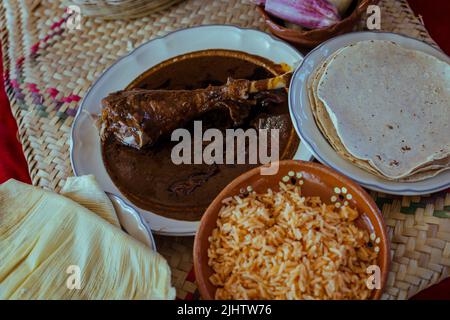 Eingewickelt mit Mole aus San Lucas Atzala, Puebla mit roter Maistortilla Stockfoto