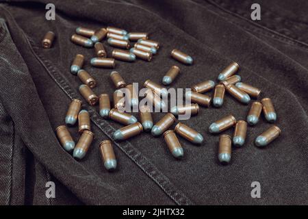 .45 ACP-Patronen auf schwarzem Denim-Hintergrund Stockfoto