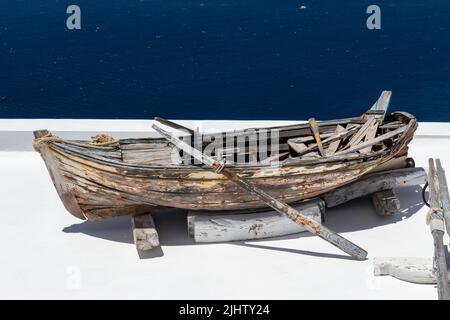 Altes verwittertes Ruderboot aus Holz auf einem Dach in Firostefani, Santorini, Kykladen-Inseln, Griechenland, Europa Stockfoto