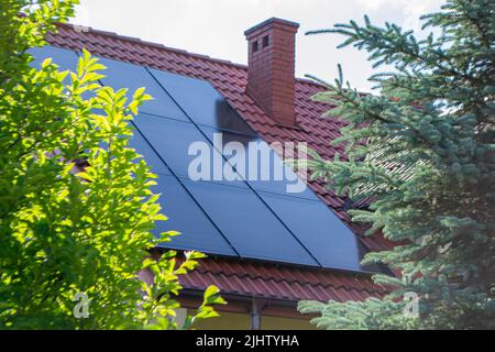 Hausdach mit Photovoltaikmodulen. Historisches Bauernhaus mit modernen Sonnenkollektoren auf Dach und Wand Hochwertiges Foto Stockfoto