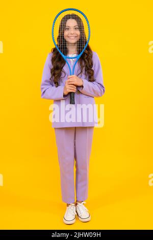 Teenager Tennisspielerin Mädchen halten Tennisschläger über isolierten gelben Hintergrund. Sport für Kinder. Ausbildung für kleines Kind. Kind lernt Tennis zu spielen. Stockfoto