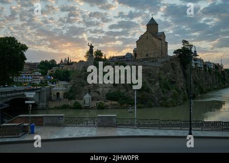 Metekhi Kirche der Geburt der Jungfrau Maria und das Denkmal des Königs Vakhtang Gorgasali in Alt-Tiflis Blick auf den Sonnenuntergang mit Wolken am Himmel Stockfoto