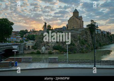 Metekhi Kirche der Geburt der Jungfrau Maria und das Denkmal des Königs Vakhtang Gorgasali in Alt-Tiflis Blick auf den Sonnenuntergang mit Wolken am Himmel Stockfoto