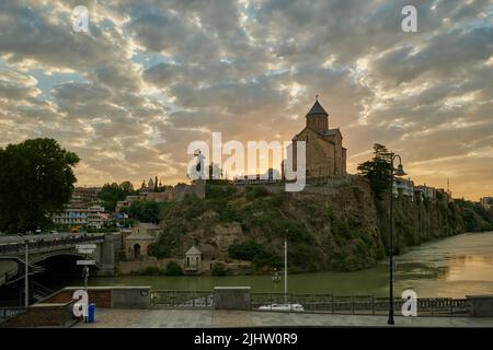 Metekhi Kirche der Geburt der Jungfrau Maria und das Denkmal des Königs Vakhtang Gorgasali in Alt-Tiflis Blick auf den Sonnenuntergang mit Wolken am Himmel Stockfoto