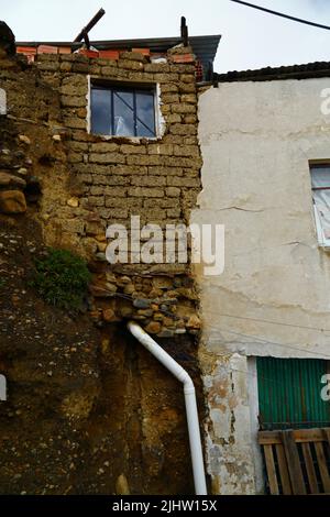 La Paz, Bolivien: Ein schlecht gebautes lehmziegelhaus mit unsicherem Entwässerungssystem, das Wasserfiltration und Bodenerosion der Fundamente im Stadtteil Tembladerani/Cotahuma verursacht. Viele der Stadtviertel am Hang von La Paz wurden in instabilen Gebieten ohne entsprechende Genehmigungen oder Gebäudekontrollen errichtet. Absenkungen und Erosionen, die Erdrutsche und Häuser zum Einsturz bringen, sind vor allem in der Regenzeit üblich. Stockfoto