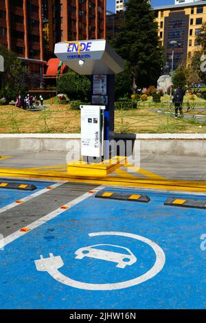 La Paz, Bolivien. Eine Ladestation für Elektrofahrzeuge an der Plaza Bolivia, Bezirk Sopocachi. Bolivien verfügt noch immer über sehr wenige Elektrofahrzeuge, aber das staatliche Elektrizitätsunternehmen ENDE (Empresa Nacional de Electricidad) Corporation hat in den Hauptstädten Ladestationen installiert Stockfoto