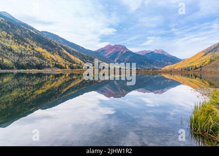 Spiegelung herbstlicher Espenbäume entlang des Crystal Lake am Red Mountain Pass in den San Juan Mountains von Colorado Stockfoto