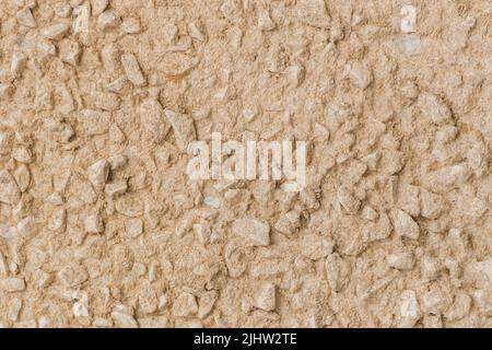 Sand gelb beige Farbe Farbe Farbe auf Stein Kieselstein Oberfläche solide Textur Wand Hintergrund. Stockfoto