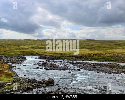 Fantastische Landschaft mit fließenden Flüssen und Bächen mit Felsen und Gras in Island Stockfoto