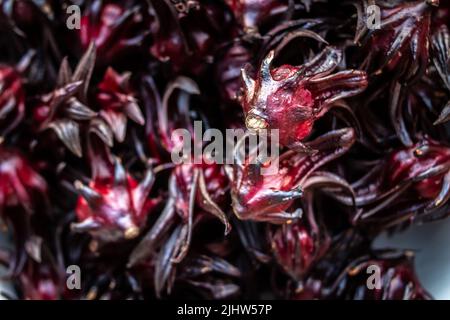 Nahaufnahme einer Schüssel voller Hibiskus-Sabdariffa oder Sorrel, einer reichen roten Blume, die in karibischen Ländern zur Weihnachtszeit für Sorrel-Getränke verwendet wurde. Stockfoto